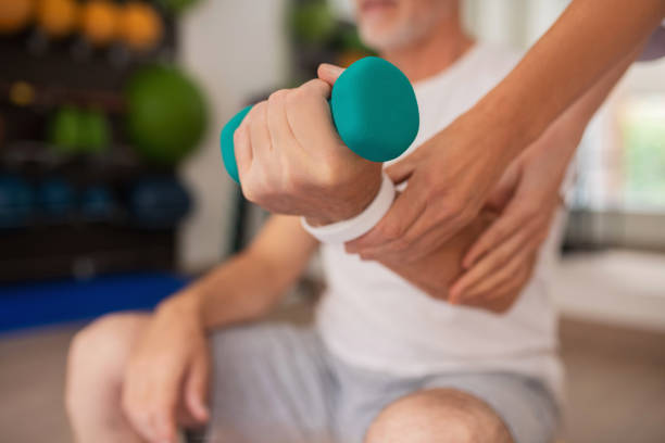 With dumbbell. Close up picture of human hand with a dumbbell